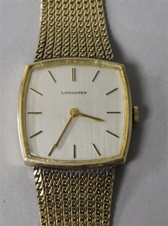 A gentlemans gold plated Longines manual wind dress wrist watch, on a gold plated bracelet.